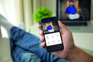Man-on-the-sofa-using-the-phone-with-app-smarthome-on-the-screen-in-the-living-room-RET