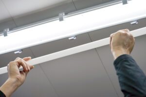 asset-12453194_Electric_hands_changing_ceiling_fluorescent_lamp._The_concept_of_repair_and_service-1